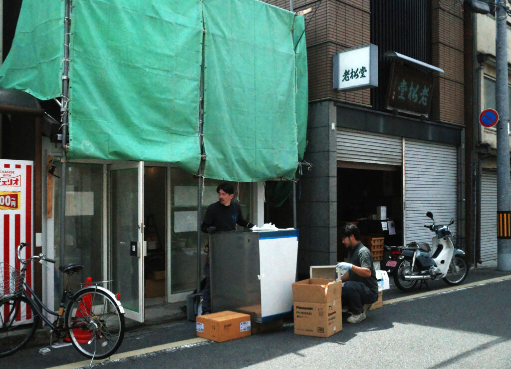 京都・東山の洋菓子店店舗内装現場で換気設備を搬入する職人さん