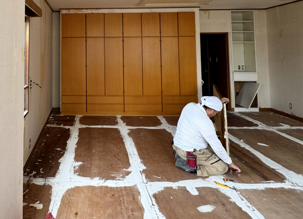 床材をめくりながら作業する職人さん｜京都 新町松原 レンタルオフィス 店舗改装 解体作業