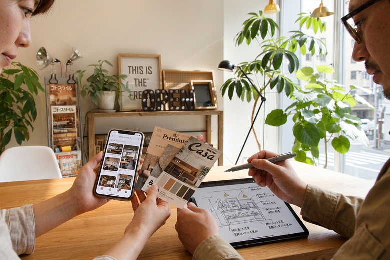オーナーがスマホ、タブレット、切り抜いた写真（Pinterest的なイメージボード）を差し出し担当者と一緒に覗き込んでいる手元中心のカット