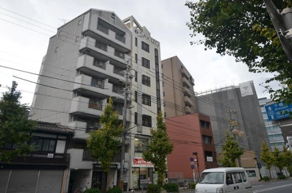 GEN SAKIZO河原町五条を反対側から見た外観。左隣のバルコニーのある建物と周辺の街並み