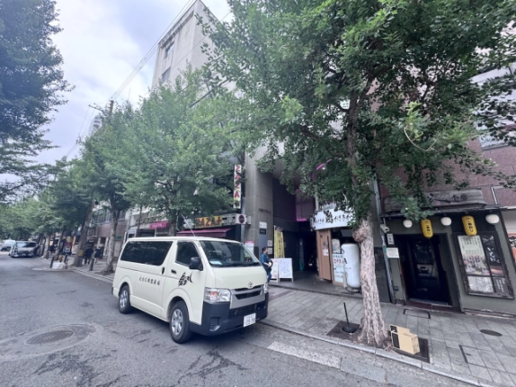 三条駅徒歩5分の店舗事務所が入る木屋町不動ビル。街路樹越しに見た外観と前面道路