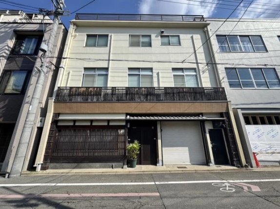 夷川通の向かい側から見た建物正面。各階に並ぶ窓と1階の格子窓、右側のシャッター