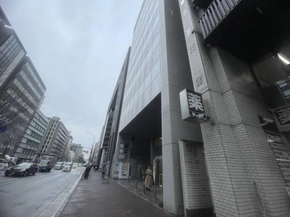 貸事務所が入るビルを歩道から見上げた外観。窓の並ぶ上階と1階の奥まった入口