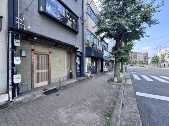 京都市上京区・衣笠第7ビルの1階貸店舗外観。格子戸の入口と今出川通の街路樹