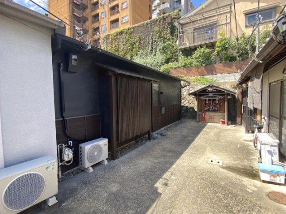 京都市上京区西富仲町・西陣の杜の外観。路地に面した平家の格子戸と濃い色の外壁