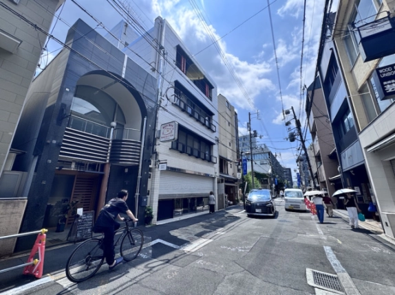 寺町二条店舗を左手に見た寺町通。アーチのある建物と向かい側の店舗