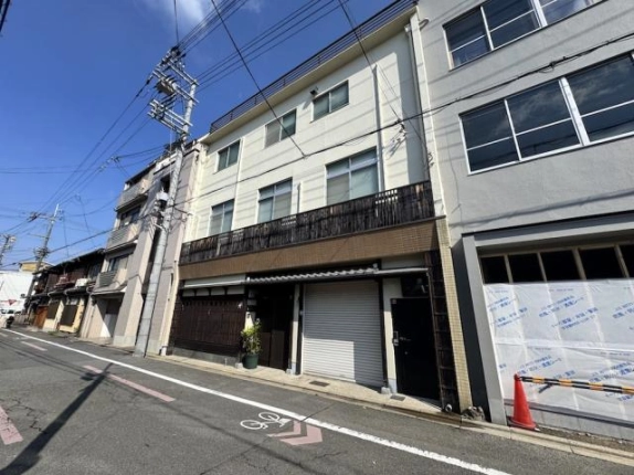 京都市中京区泉町・衣棚夷川店舗の外観。白い3階建てと2階の長い格子状の手すり