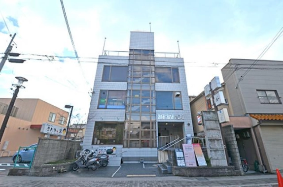 京都市北区大宮北椿原町・髙山ビルの正面外観。中央の縦長のガラス面と入口へ上がる階段