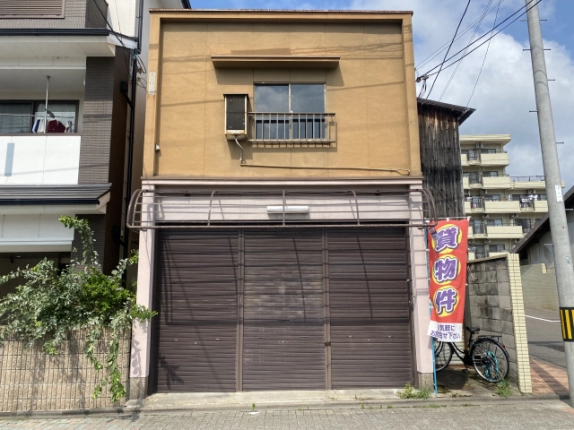 京都市上京区東竪町の貸店舗正面。黄土色の外壁と1階の茶色いシャッター