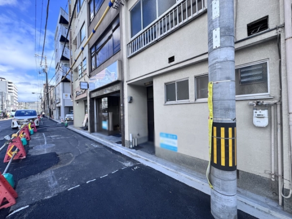 壬生馬場町一棟店舗の入口近景。奥まった扉と横長の小窓、建物前の電柱