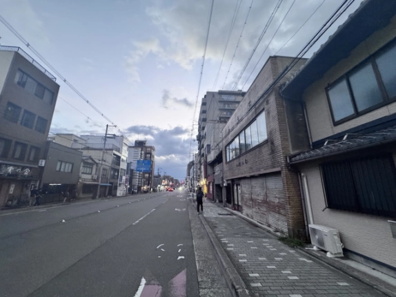 米屋町京町家を右手に見た前面道路。歩道沿いに続く建物と向かい側の街並み