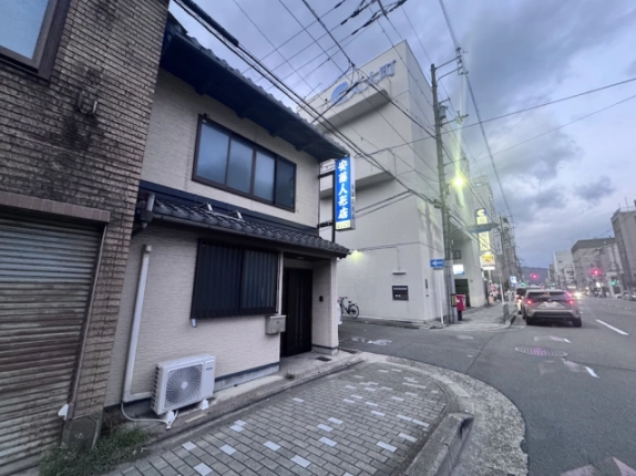 米屋町京町家を左手に見た外観。瓦のひさしと建物脇の道路