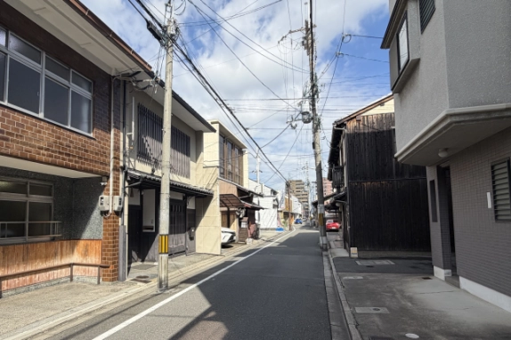 大宮通の通り沿いの様子。左手にレンガ調の建物と並んで縦格子の京町家テナントがあり、右手には黒い板張りの建物が見える