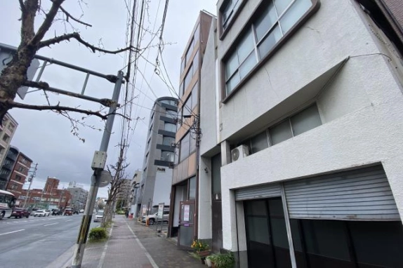 西大路御池駅周辺の建物を歩道から見上げた外観。中央奥の茶色い建物と右手前の白い隣接建物