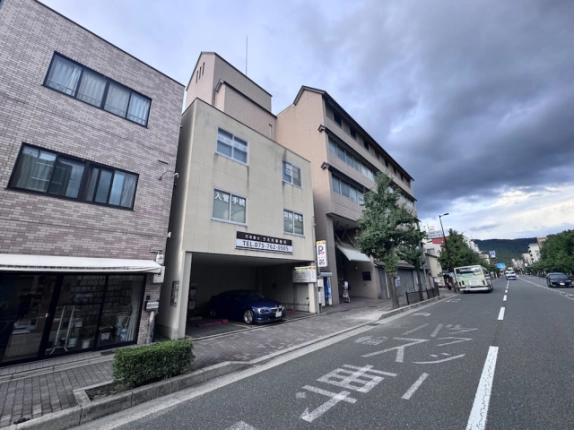 京都市左京区東丸太町・上田ビルの外観。淡い色の壁と1階の駐車スペース