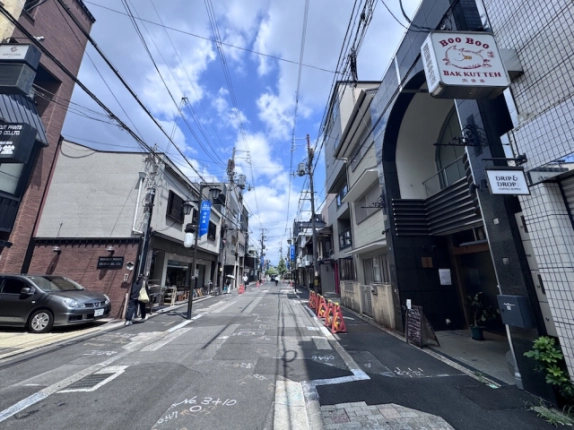 寺町二条の店舗事務所前の街並み。右側に建物の入口と突出し看板