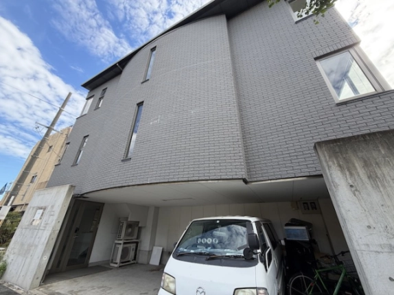 九条駅近くのテナント建物を見上げた外観。レンガ調の外壁と縦長の窓