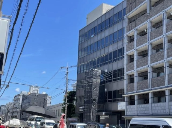 清水五条スクエアを斜めから見上げた外観。上階の窓並びと右隣の集合住宅