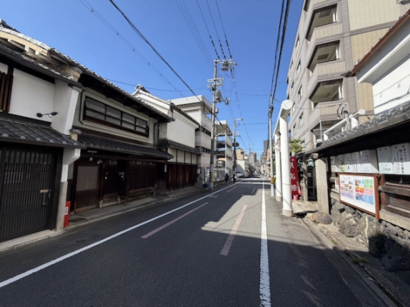 町家を左手に見た釜座通。右側の塀と掲示板、奥へ続く前面道路