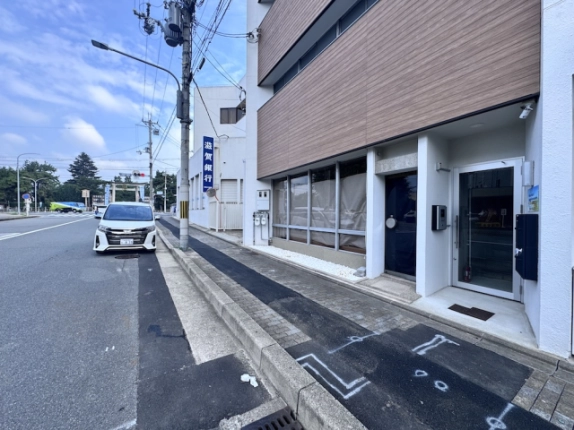 西工務店ビルの入口を斜めから見た様子。右手のガラス扉と前面歩道