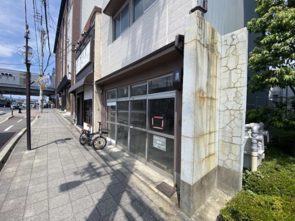 七条通沿いの朱雀正会町店舗を斜めから見た外観。ガラス戸の前に続く歩道