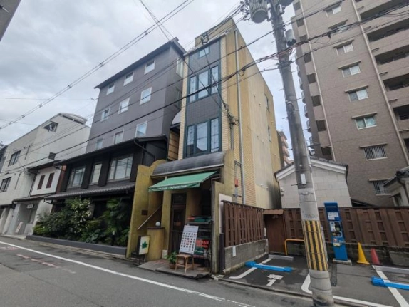 3・4階で店舗・事務所を募集する建物の外観。黄色い側面と右隣のコインパーキング