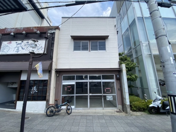 京都市下京区朱雀正会町の貸店舗正面。白い外壁と1階の大きなガラス戸