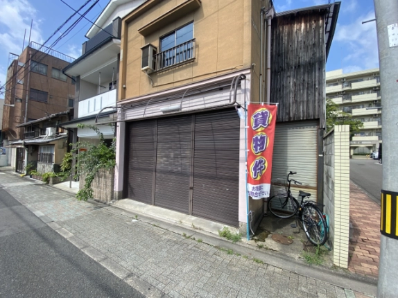 東竪町店舗の1階前を斜めから見た外観。シャッターと右側の貸物件ののぼり