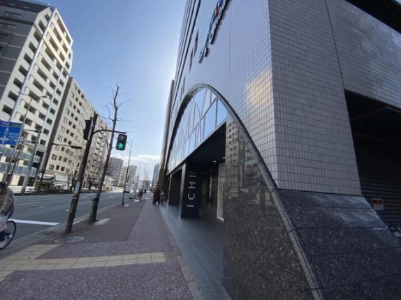 京都烏丸万寿寺ビルを右手に見た前面歩道。建物角の石張り部分と街路樹