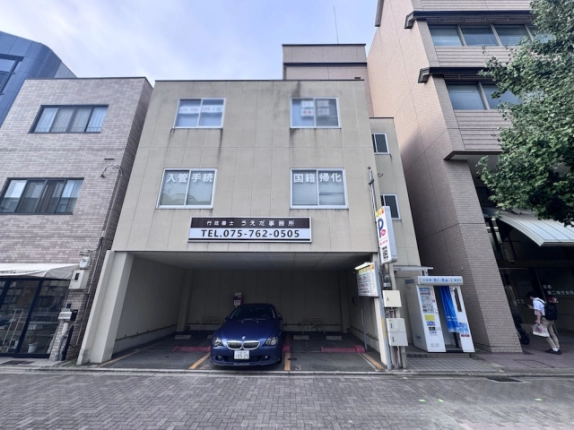 上田ビルを正面から近くで見た外観。上階の窓と建物下部の広い駐車開口部