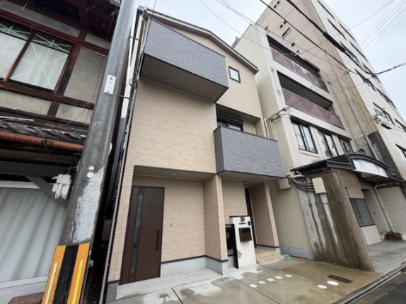 建物を反対側から見た全景。左隣の木造建物と右隣の中高層建物