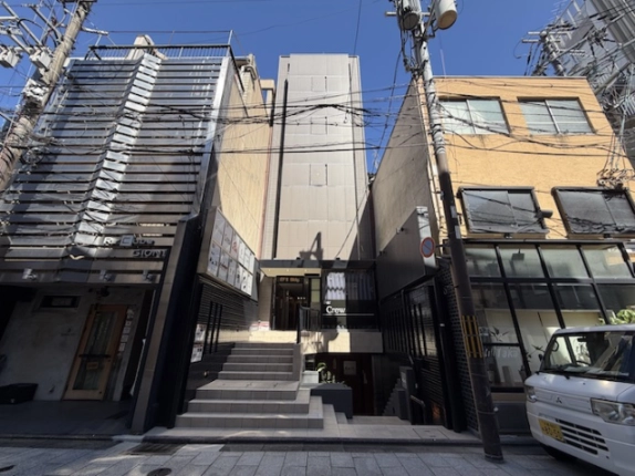 祇園町北側の通りから見上げた第二EFビルの正面外観。細長いベージュ系の建物で、通りから入口へタイル張りの階段が上がっている