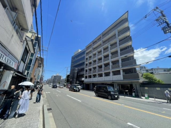 清水五条駅周辺の前面道路と歩道。右手に隣接する集合住宅、その奥に物件の建物