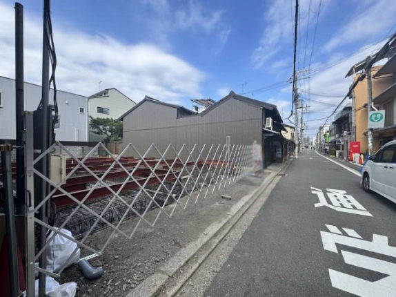 建設現場を左手に見た前面道路。路面の通学路表示と通り沿いの住宅