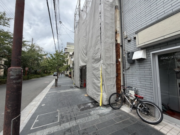 清水五条駅徒歩6分の木屋町松原店舗周辺。養生シートの掛かった建物と隣接建物、歩道の街灯