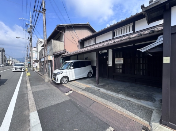 山ノ内宮前町京町家を反対側から見た外観。格子のある玄関と左手に続く三条通