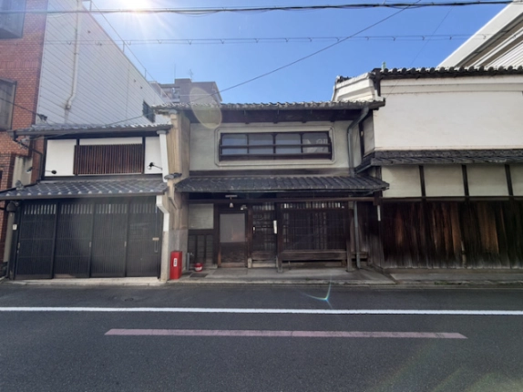 釜座通の向かい側から見た突抜町貸家。中央の町家と左右に連なる瓦屋根の建物
