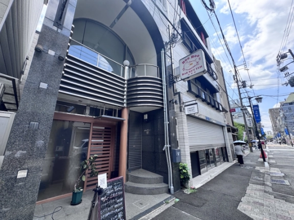 寺町二条店舗の2階正面を見上げた様子。アーチ形の開口と丸みのある手すり