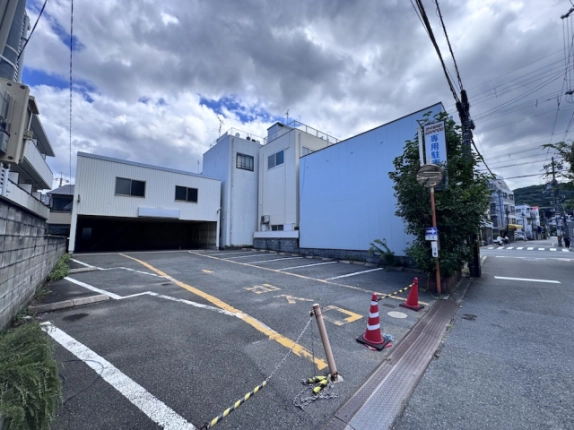 道路側から見た駐車場の入口と建物側面。区画線と出入口の様子