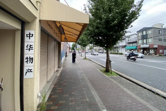 店舗を左手に見た東大路通。ひさし沿いの歩道と街路樹、向かい側の建物