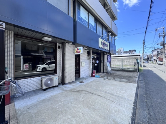 三輝ビル1階店舗を反対側から見た外観。大きな窓と入口前のスペース