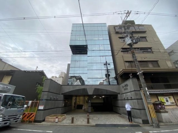 京都市中京区・ストークビル三条烏丸の正面外観。ガラス張りの壁面と石張りのエントランス