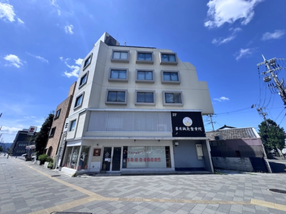 2階が貸店舗事務所のビルを正面から見た外観。横長の格子状部分と歩道