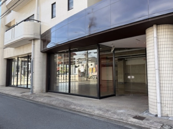 サンホワイト葛野の大型貸店舗入口。奥まったガラス扉と白いタイル張りの柱