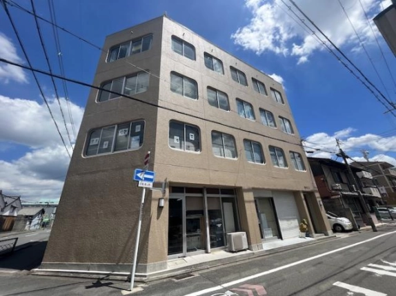 京都市上京区元頂妙寺町・澤井ビルの外観。ベージュ色の壁と角が丸い窓が並ぶ建物