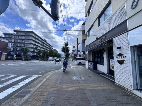 タカノビル前の交差点と北大路通。建物沿いの歩道と横断歩道