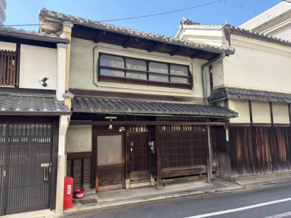 京都市中京区突抜町の京町家外観。瓦屋根と2階の横長窓、1階の木製格子戸