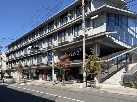 斜め前から見た2waの外観。「2wa」看板の下に1階の入口があり、右側にガラス張りの上階と上へ続く幅の広い屋外階段