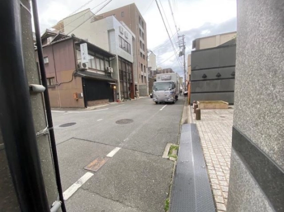 建物入口付近から見た三条通。右手の石張りの外壁と向かい側に並ぶ建物