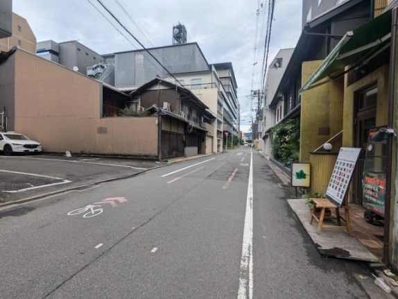 柿本町ビル前の通りを反対方向から見た街並み。右手に外階段、左手に駐車場